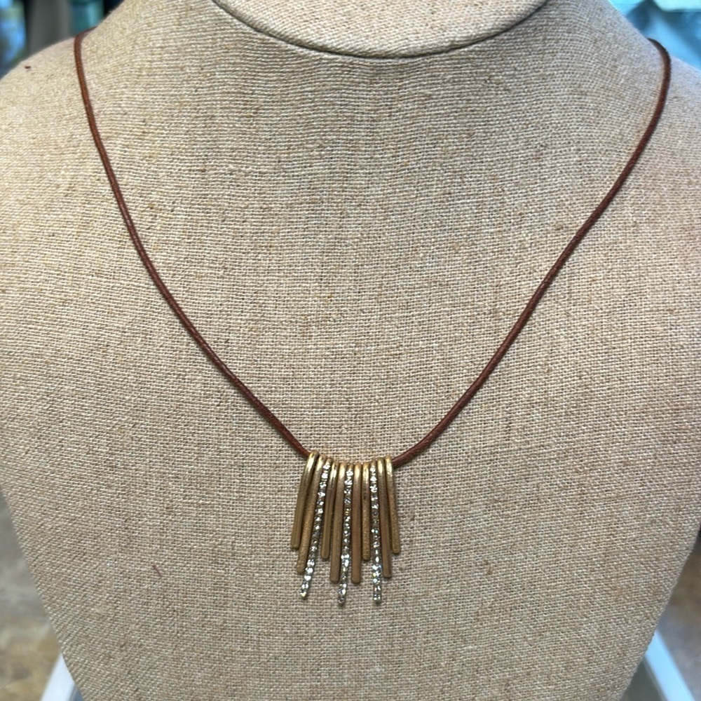 Matte gold and rhinestone pendant on brown leather cord